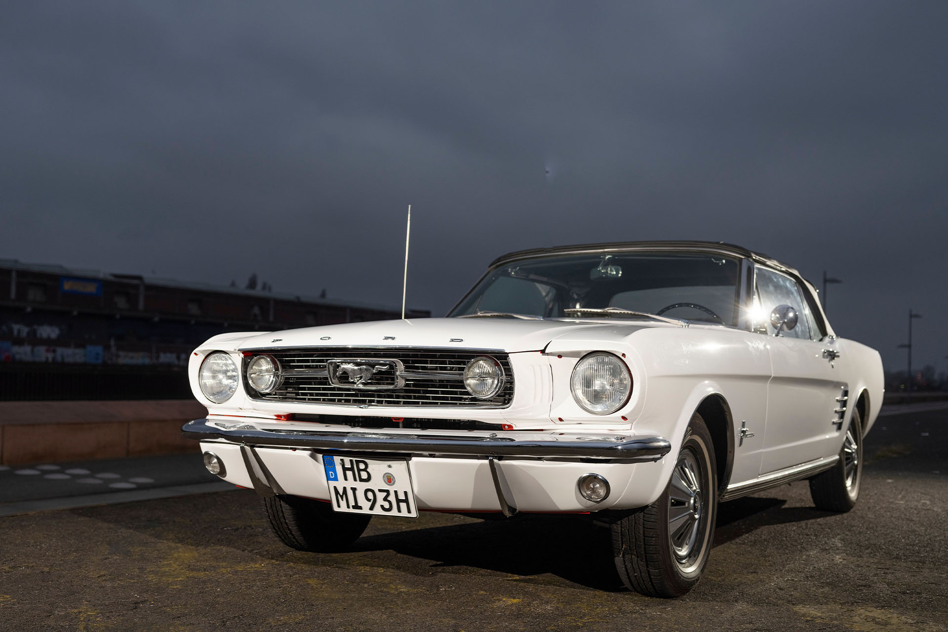 Weißes Ford Mustang Cabrio von 1966 vor dramatischem Himmel